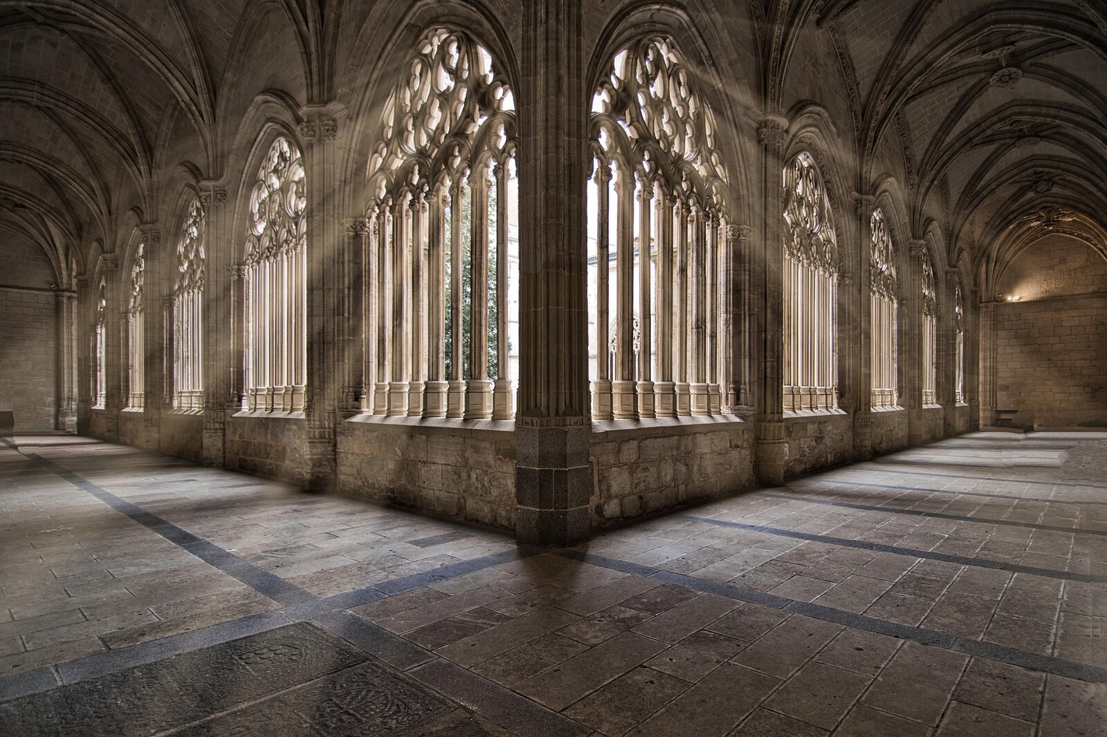 Lumière traversant les arcades gothiques d'un cloître